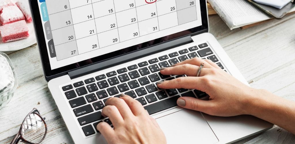 Person arbeitet an Laptop mit Kalender – Symbolbild für Digitale Zeiterfassung Pflicht im Arbeitsalltag Digitale Zeiterfassung Pflicht